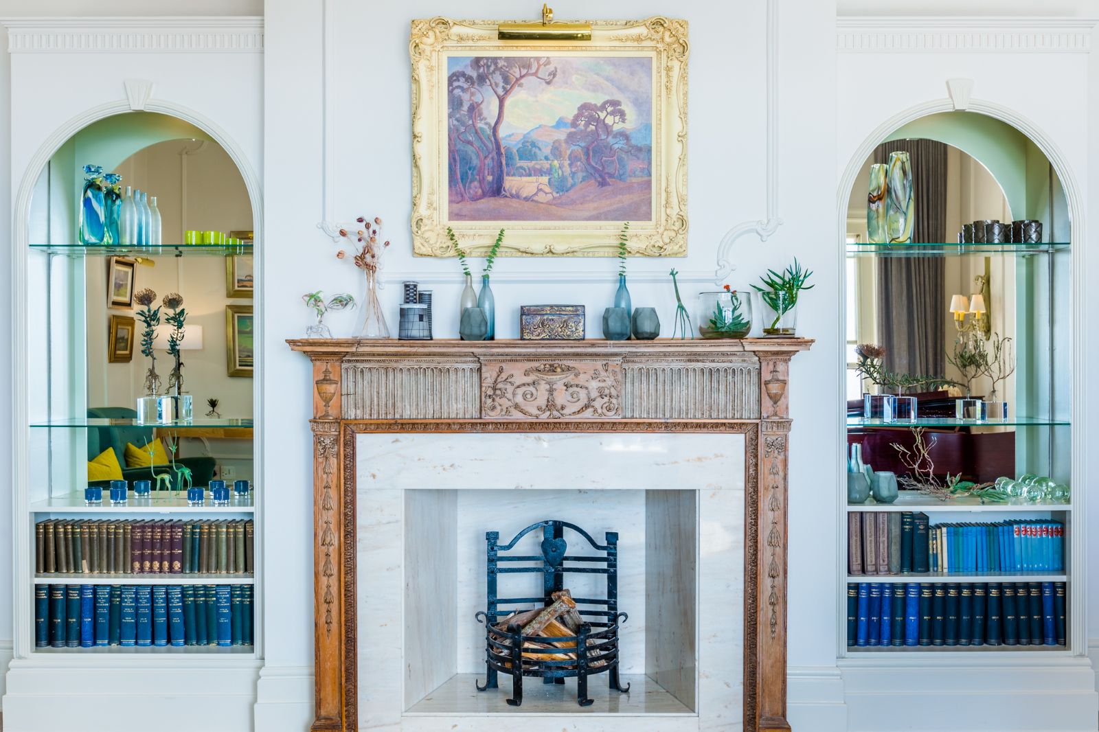 Fireplace in a lounge of luxury hotel Ellerman House in Cape Town framed by art and glass shelving