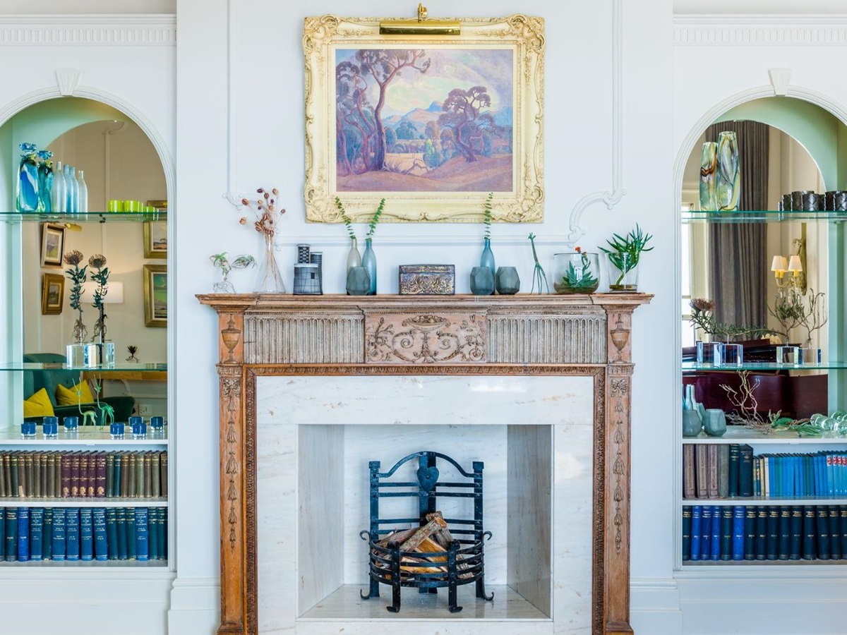 Fireplace in a lounge of luxury hotel Ellerman House in Cape Town framed by art and glass shelving