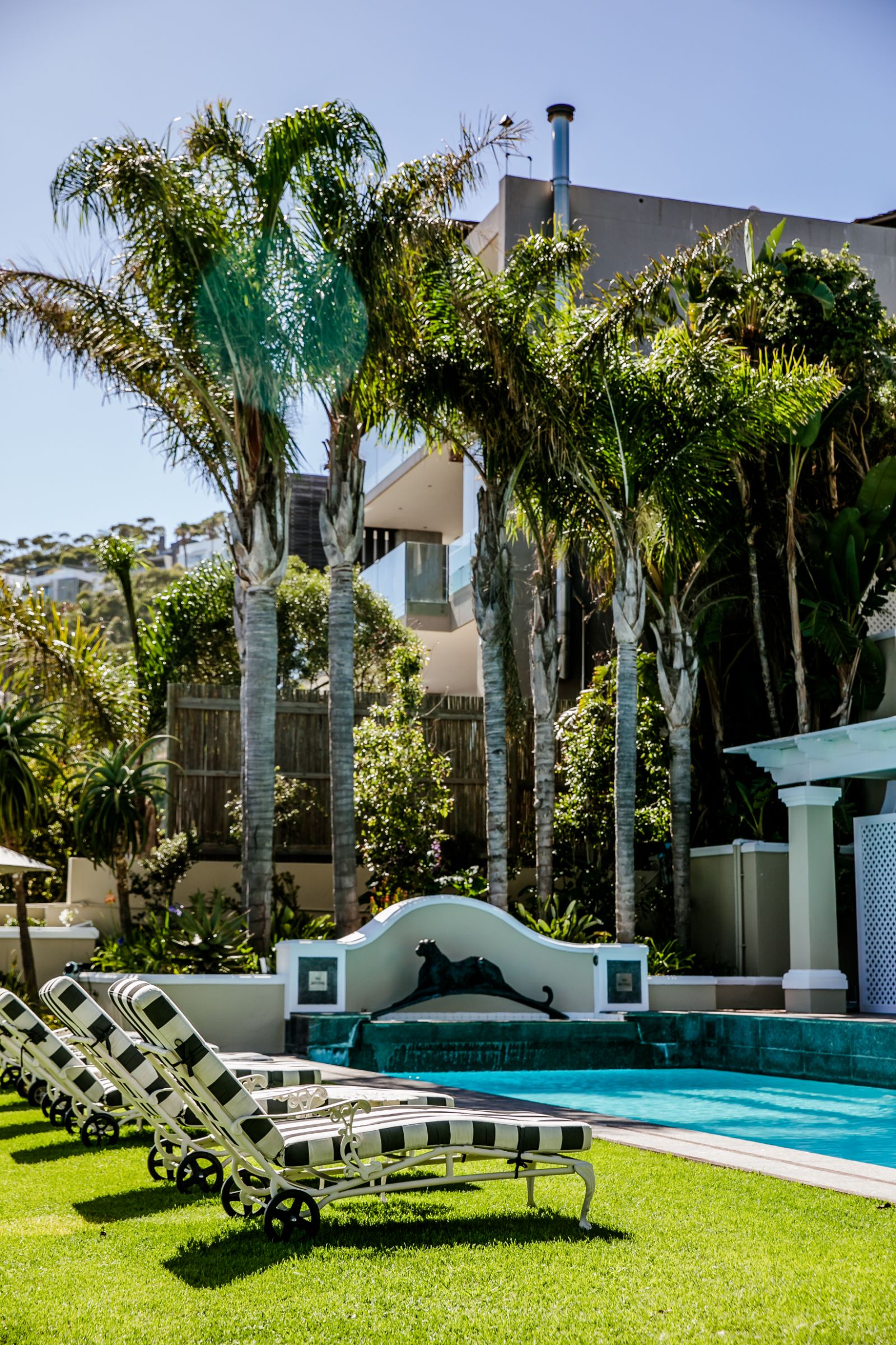 Loungers by the pool at luxury hotel Ellerman House in Cape Town featuring a Dylan Lewis sculpture