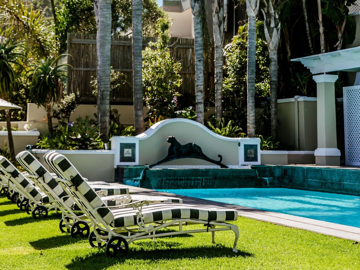 Loungers by the pool at luxury hotel Ellerman House in Cape Town featuring a Dylan Lewis sculpture