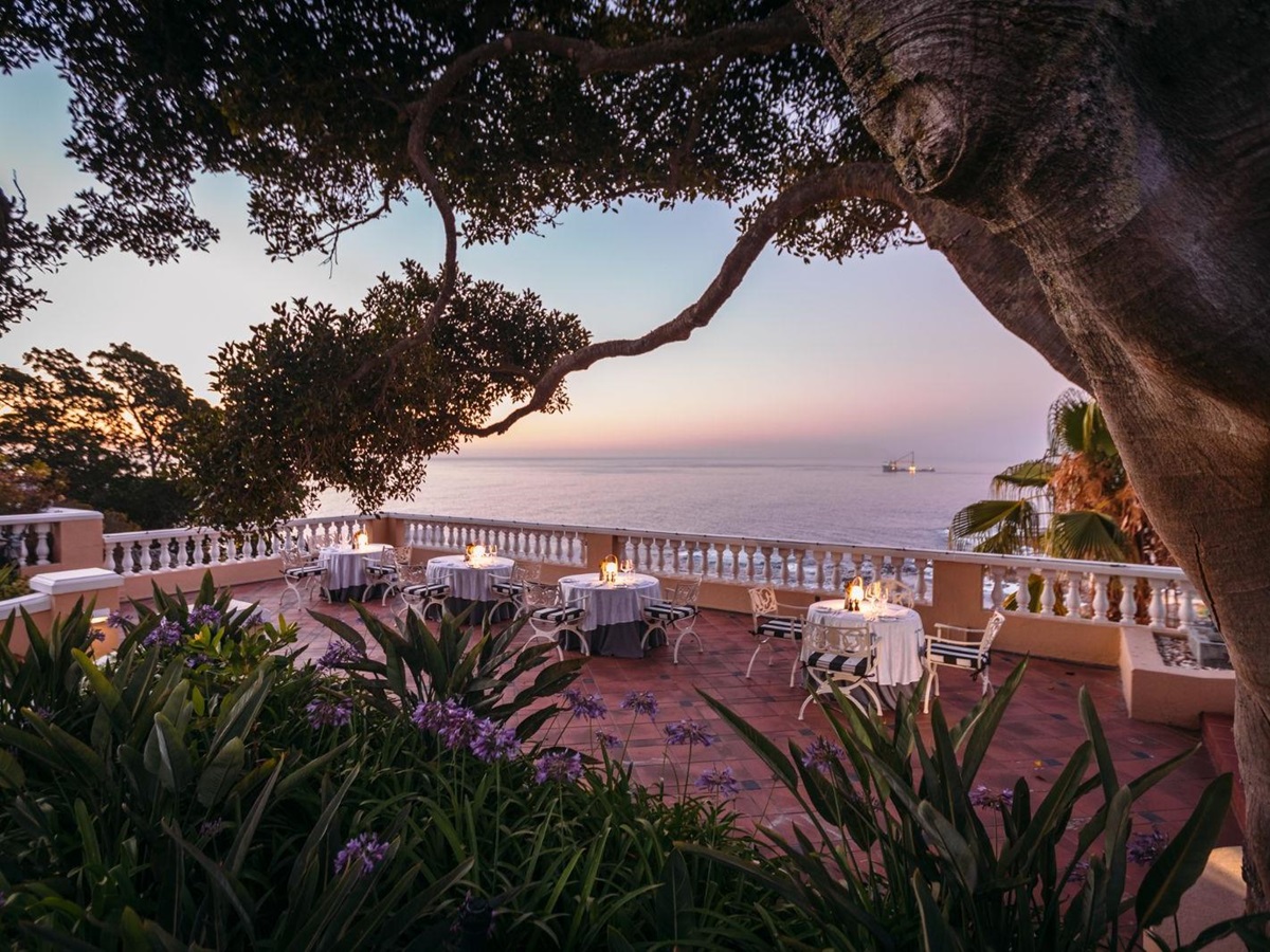 Sunset dining on the terrace of luxury hotel Ellerman House in Cape Town overlooking the sea