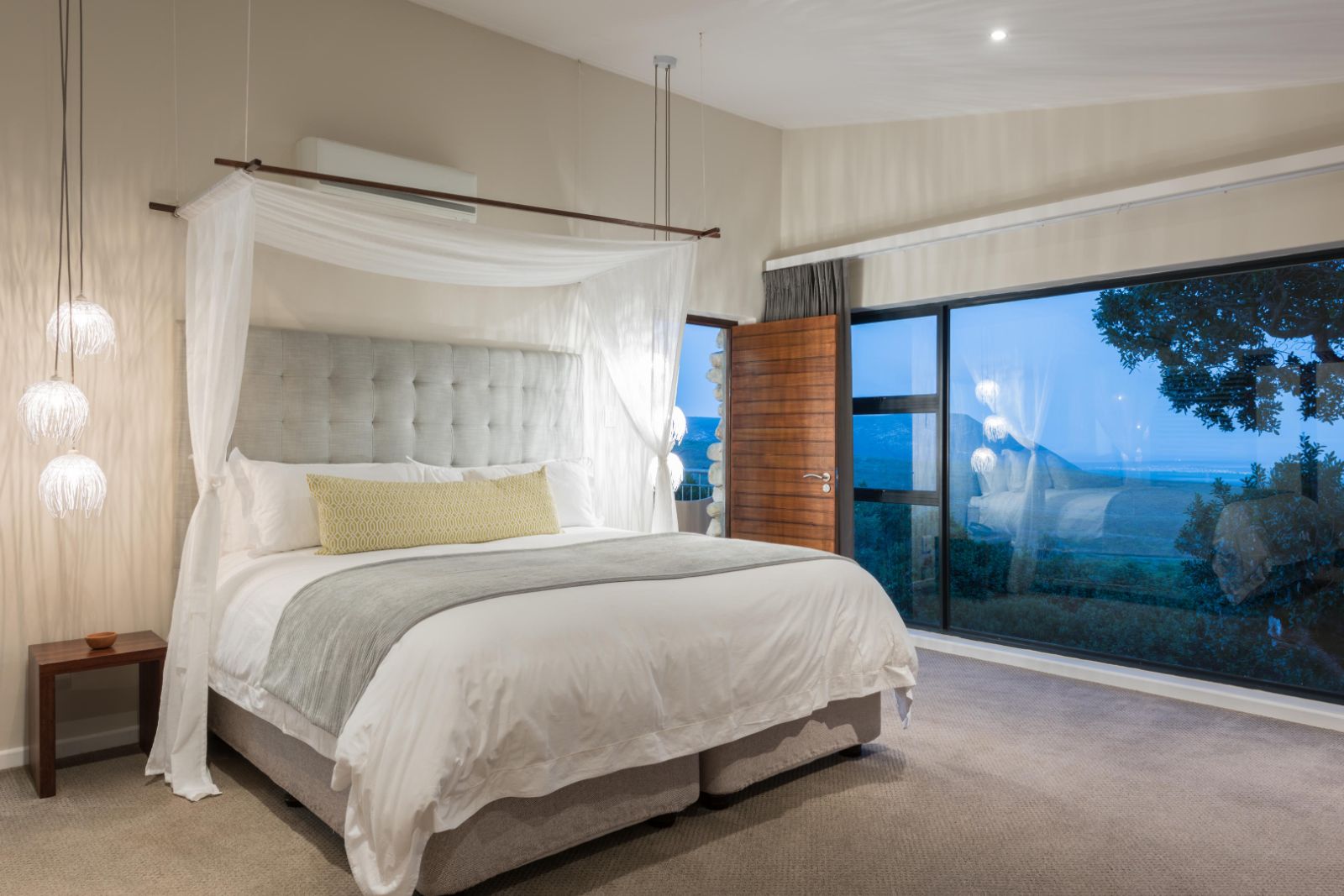 Open and bright bedroom with floor-to-ceiling windows at luxury lodge Grootbos Garden Lodge in South Africa
