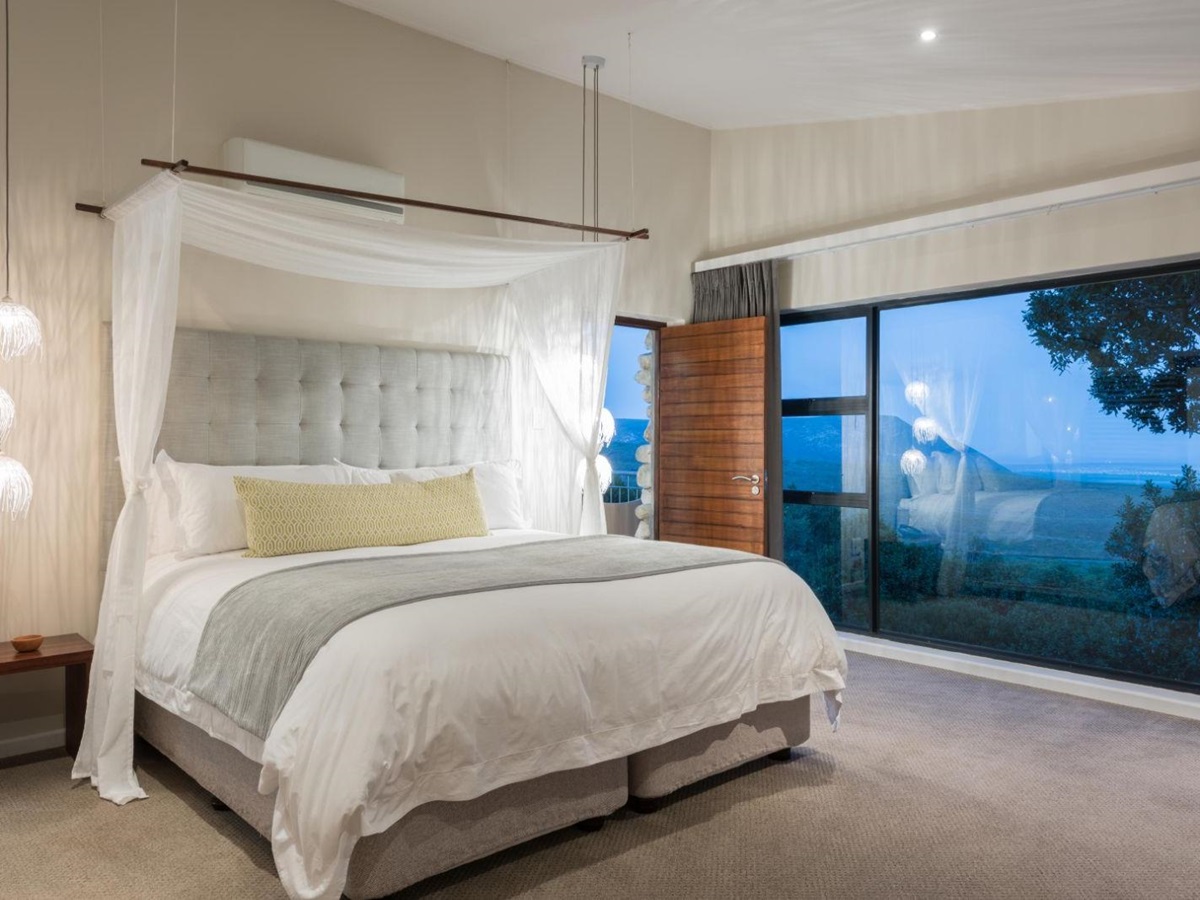 Open and bright bedroom with floor-to-ceiling windows at luxury lodge Grootbos Garden Lodge in South Africa