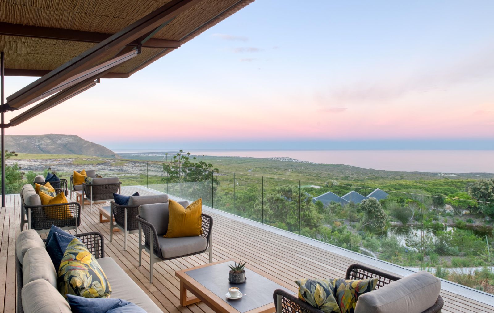 Outside lounge terrace with panoramic views of the coastline at luxury lodge Grootbos Garden Lodge in South Africa