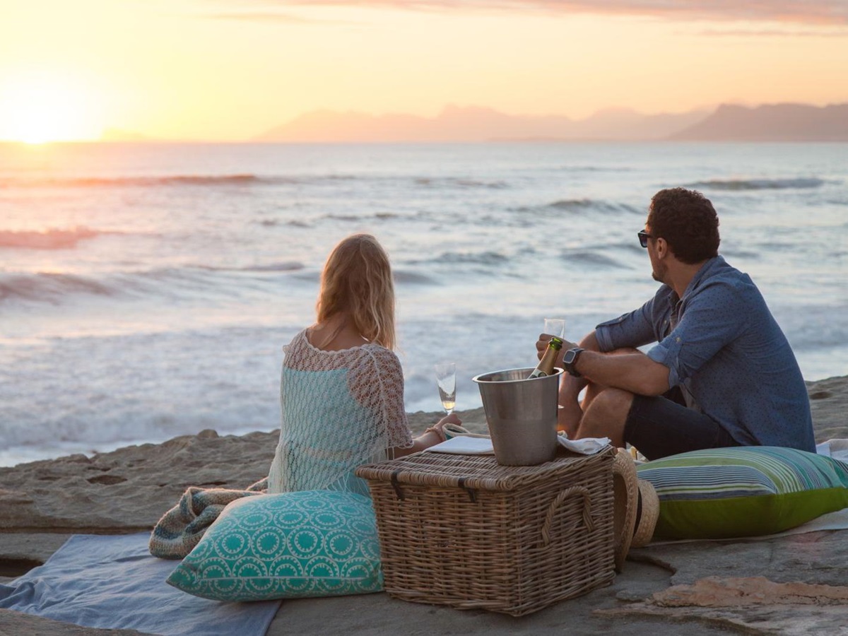 Couple enjoying a sunset beach picnic at Grootbos Private Reserve South Africa