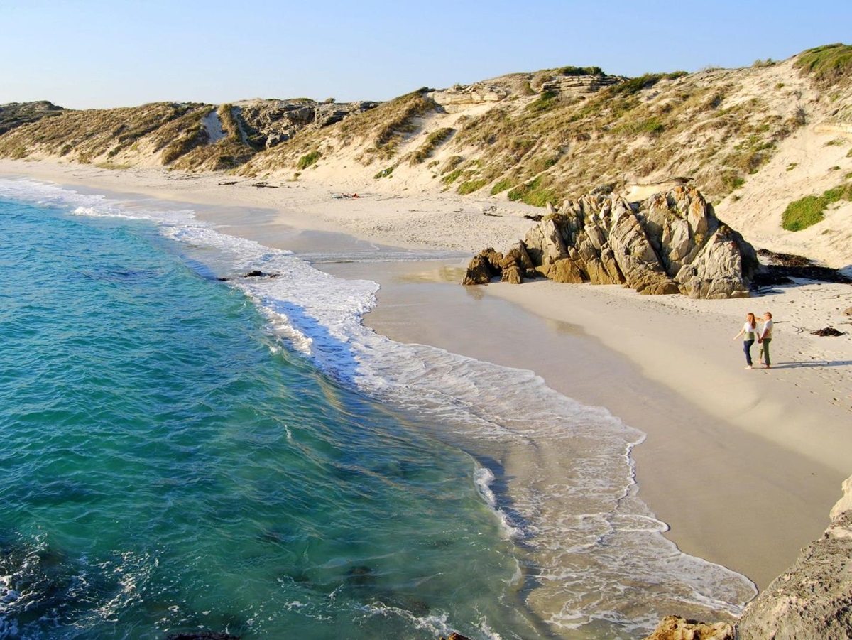 Couple walking along the white sand beach at Grootbos in South Africa