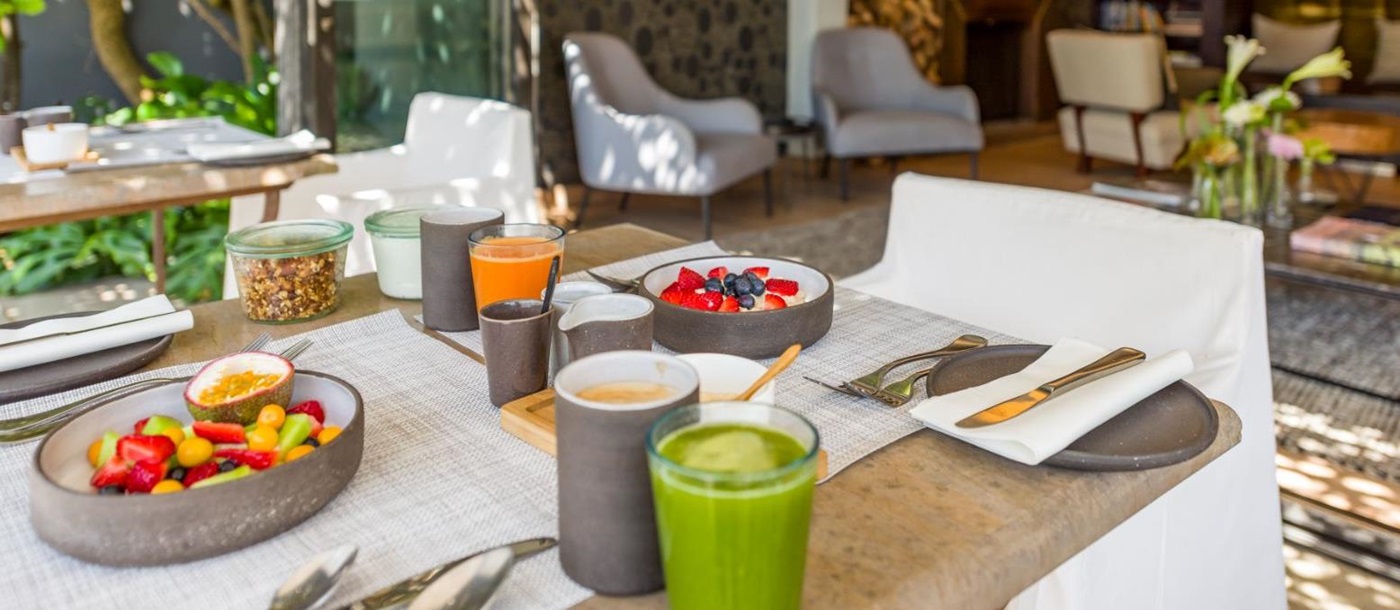 Fruit and smoothie breakfast on dining terrace of superior room at luxury hotel Kensington Place in Cape Town South Africa