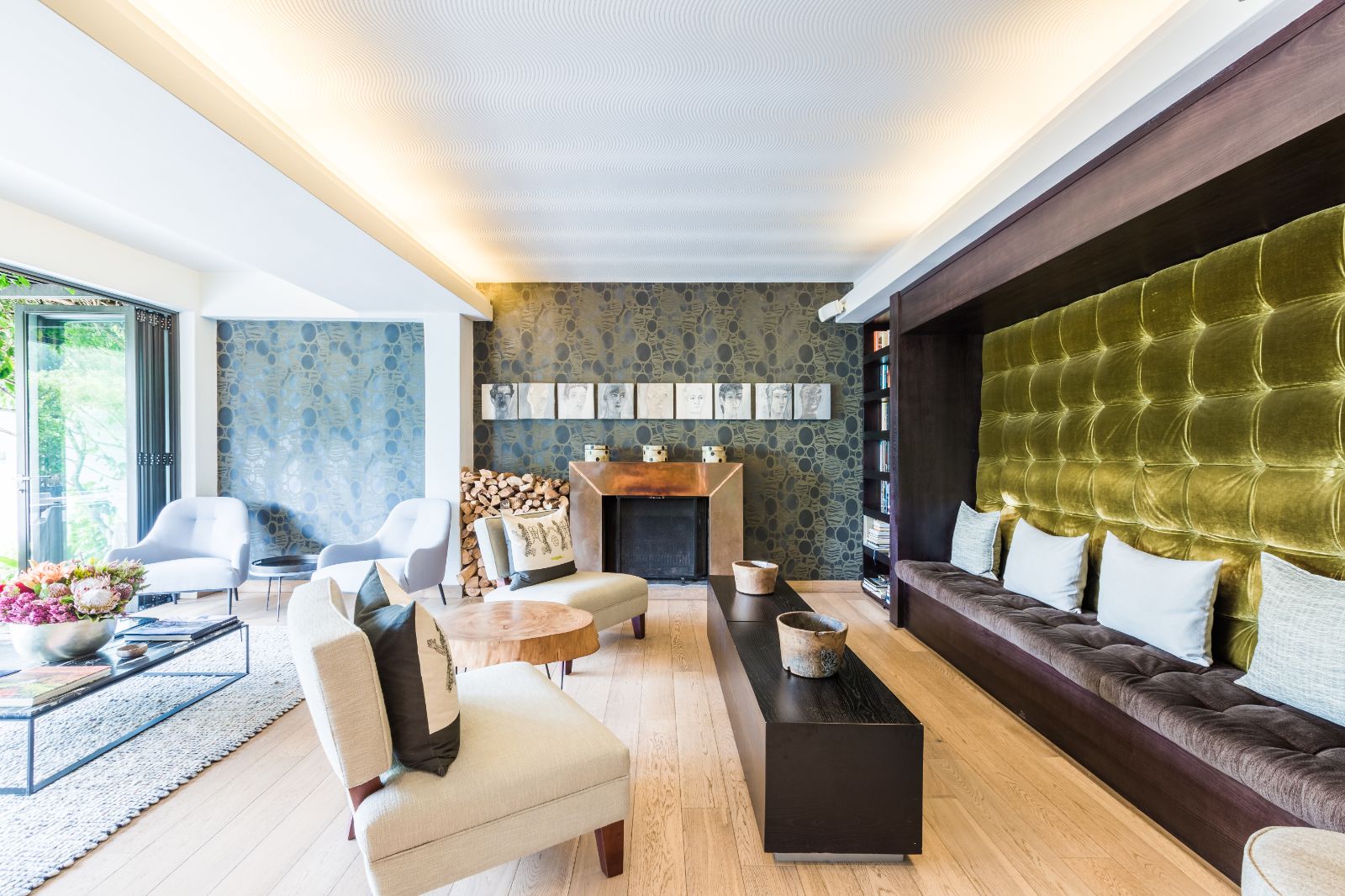 Open plan lounge area with fireplace and floor to ceiling folding doors at luxury hotel Kensington Place in Cape Town South Africa