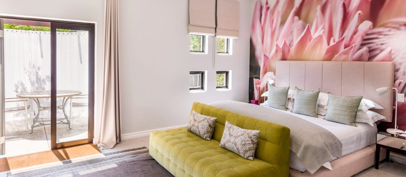 Superior room with pink aesthetic and private outside courtyard at luxury hotel Kensington Place in Cape Town South Africa