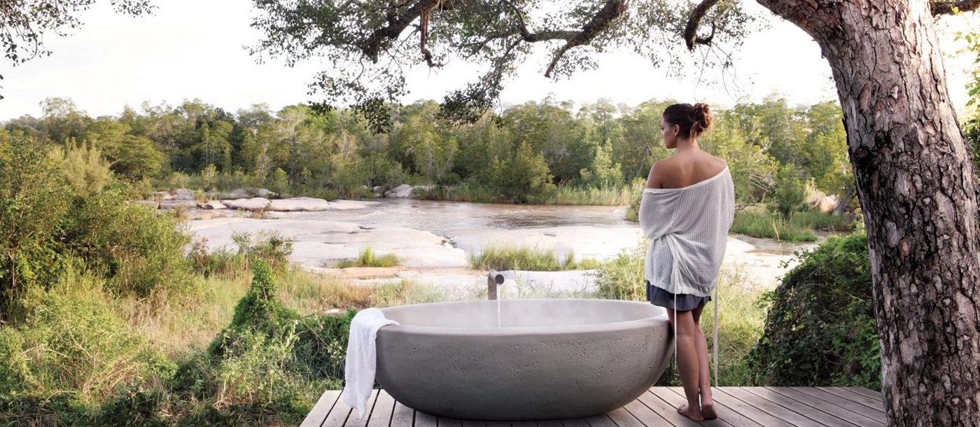 Outdoor bath with river view at Londolozi Granite Suites in South Africa