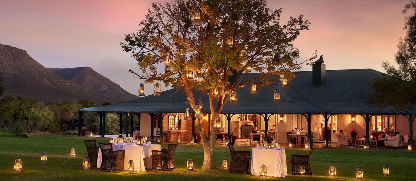Outdoor dining at sunset at luxury safari lodge, Samara Karoo in South Africa.