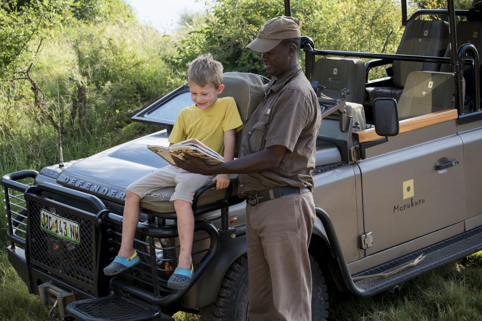 Guide explaining tracks to a young guest at luxury private house Morukuru River House in the Madikwe Game Reserve in South Africa