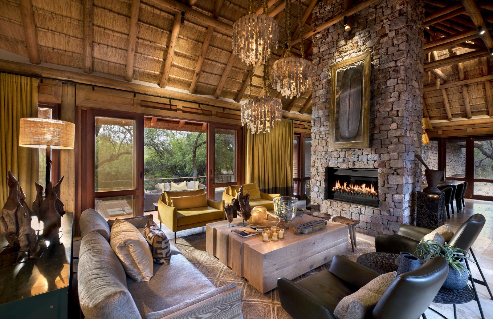 Warm and homely lounge with fireplace and cosy seating options at luxury private house Morukuru River House in the Madikwe Game Reserve in South Africa