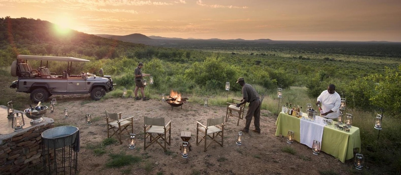 Staff setting up a scenic location for sundowners at luxury private house Morukuru River House in the Madikwe Game Reserve in South Africa