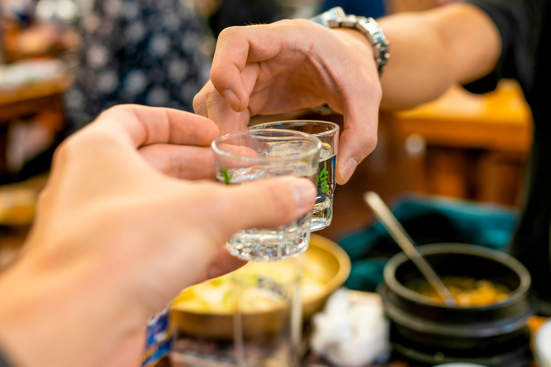 Guests drinking Soju from shot glasses in South Korea
