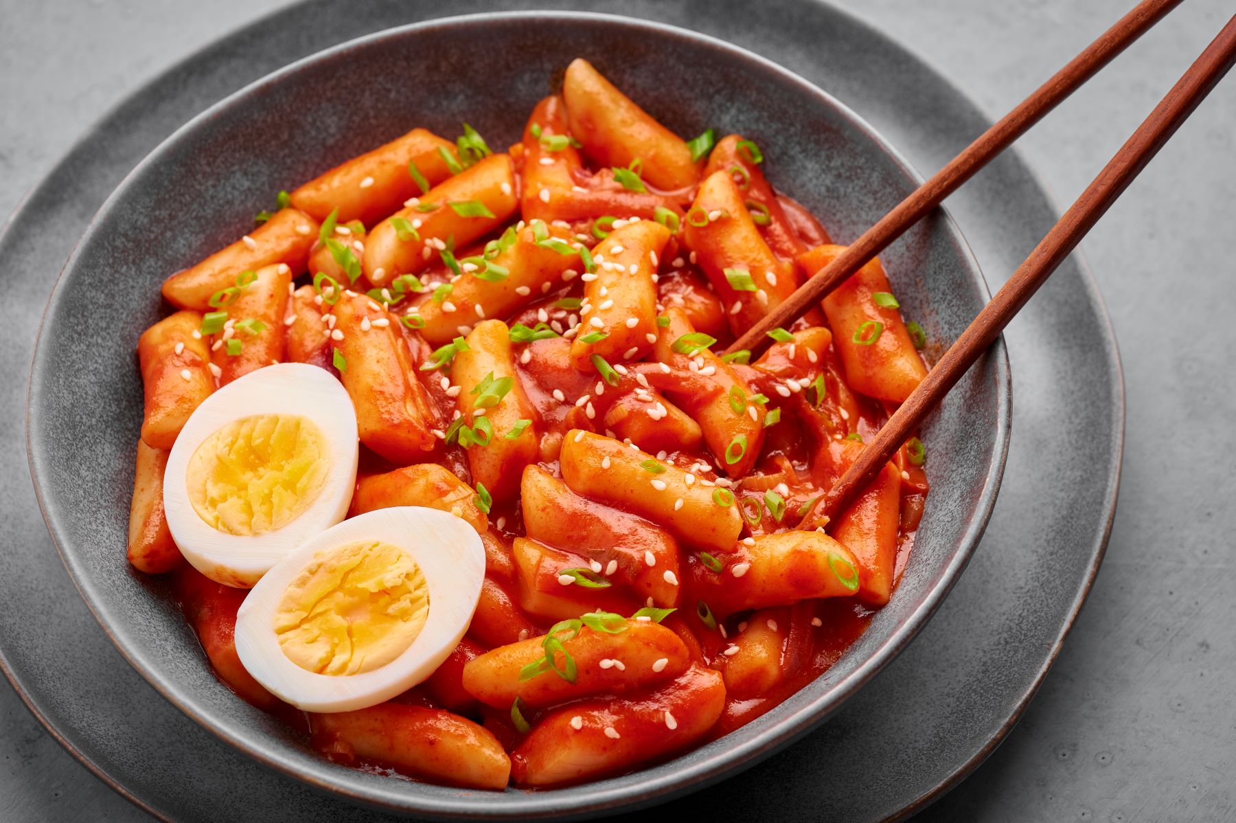 Tteokbokki served in a bowl with egg and chopsticks