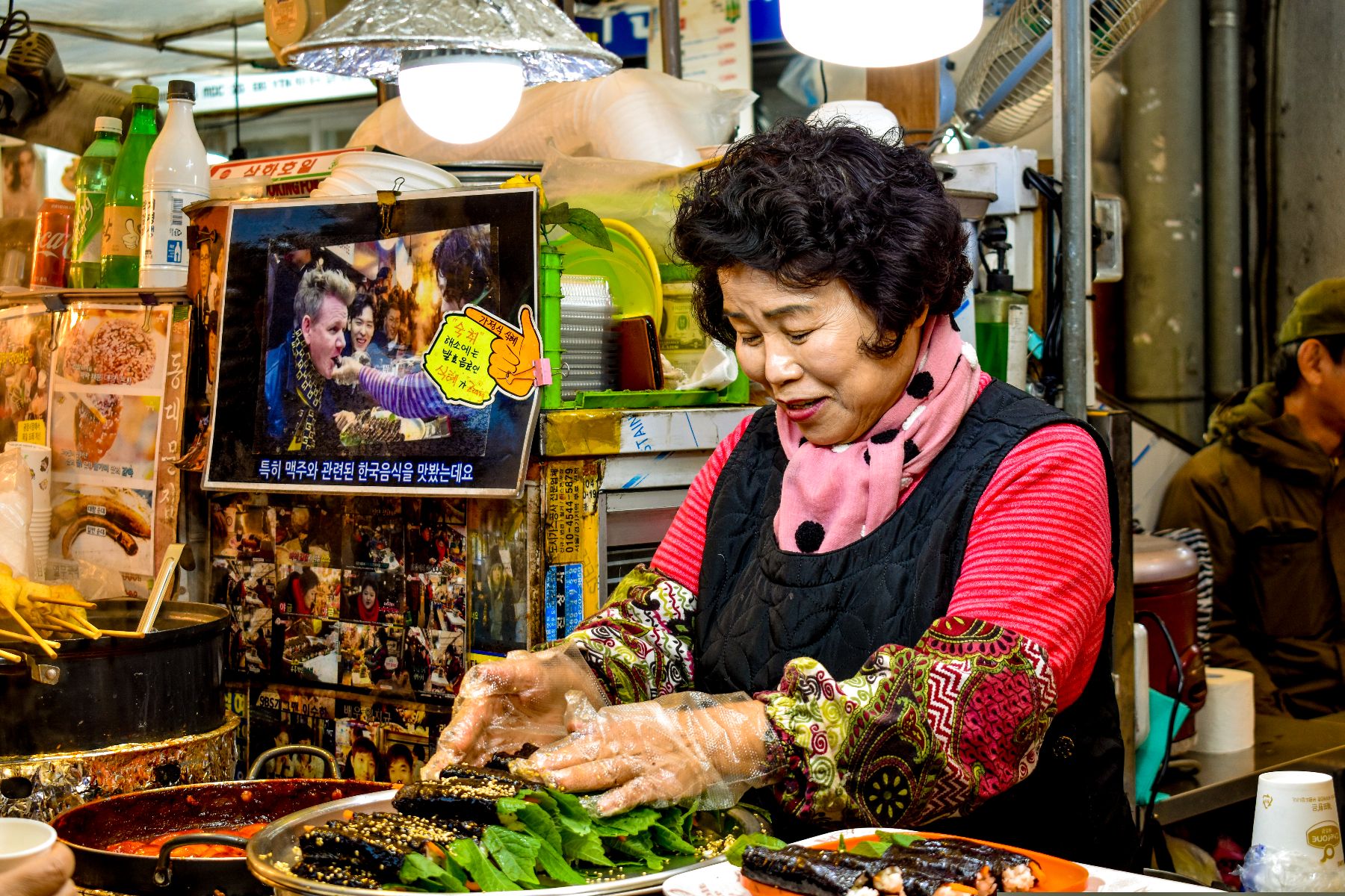 A food vendor preparing street food at Gwangjang Market in Seoul