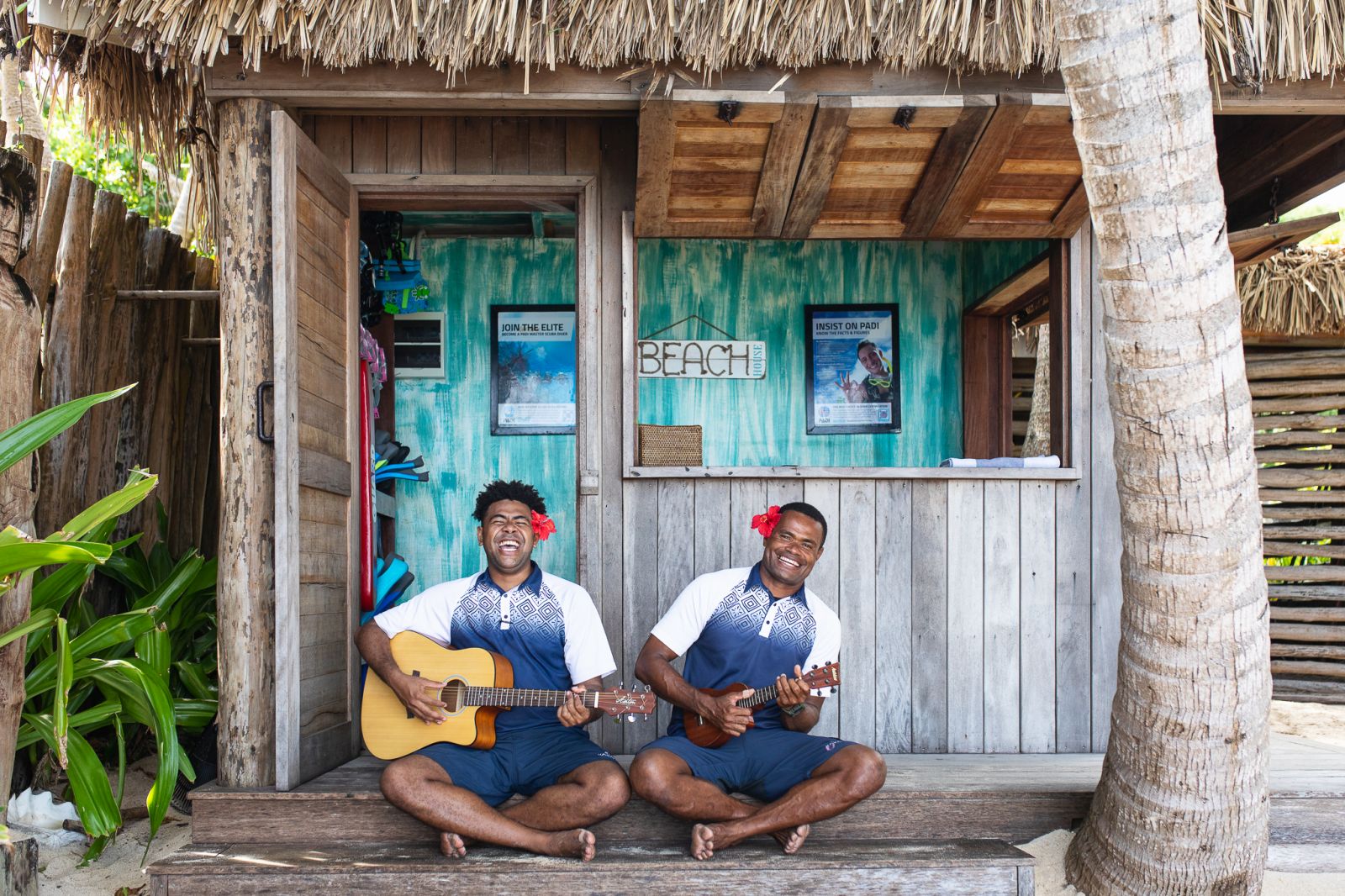 Two men playing the guitar and ukulele at luxury resort Kokomo Island in Fiji