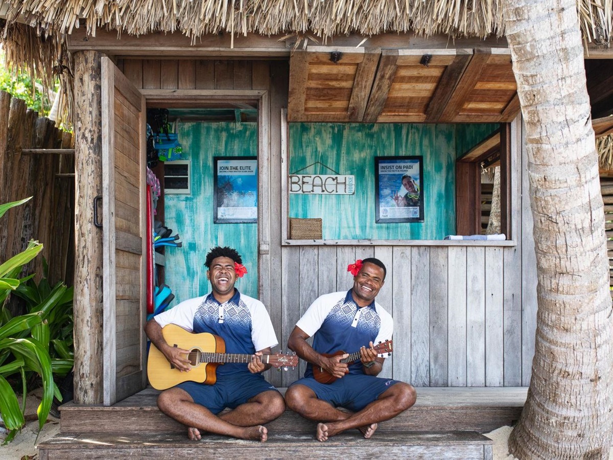 Two men playing the guitar and ukulele at luxury resort Kokomo Island in Fiji