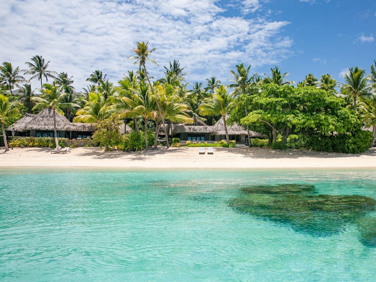 Exterior view of a sunset villa on the sand beach at luxury resort Kokomo Island in Fiji