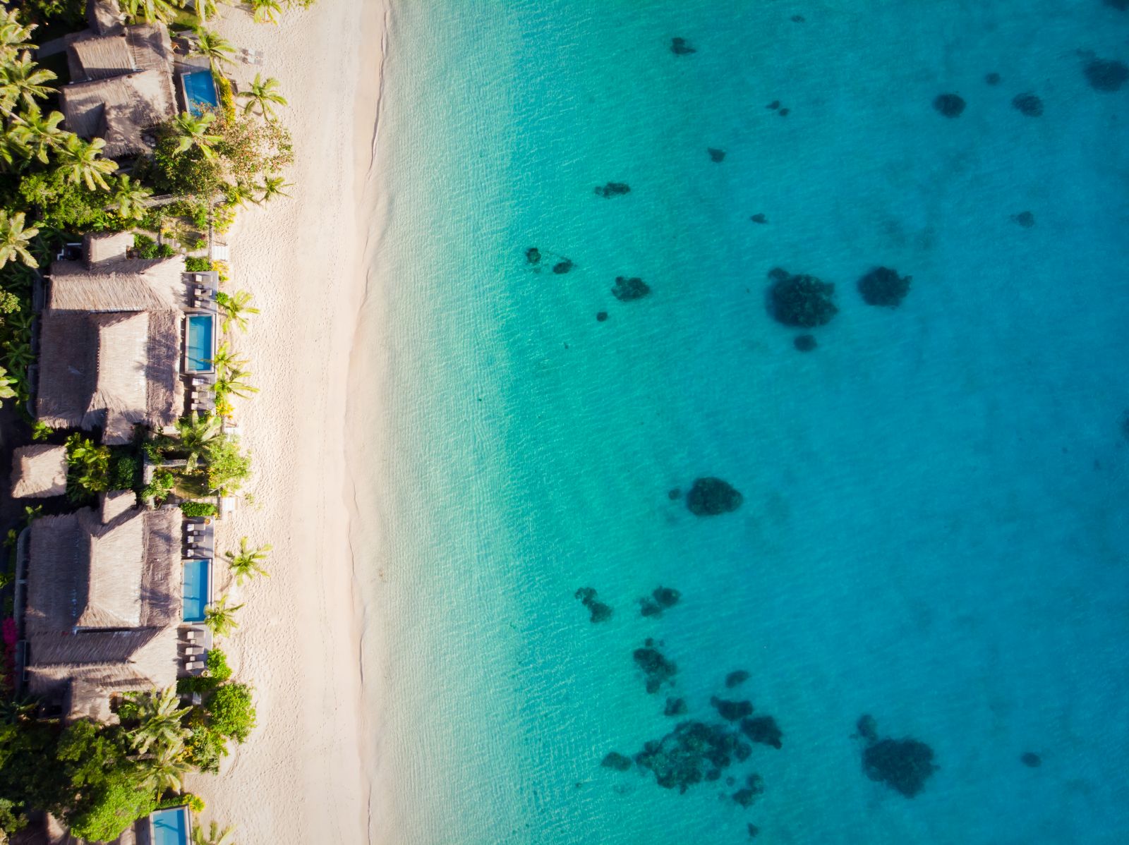 Aerial view over the villa lined West Beach at luxury resort Kokomo Island in Fiji