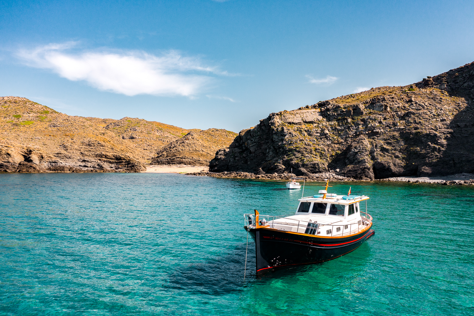 A boat moored in a secluded bay near Hotel Torralbenc in Menorca