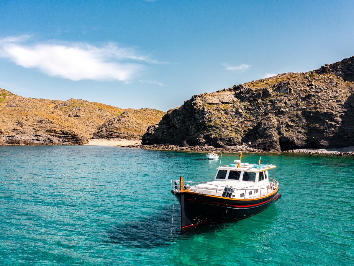 A boat moored in a secluded bay near Hotel Torralbenc in Menorca