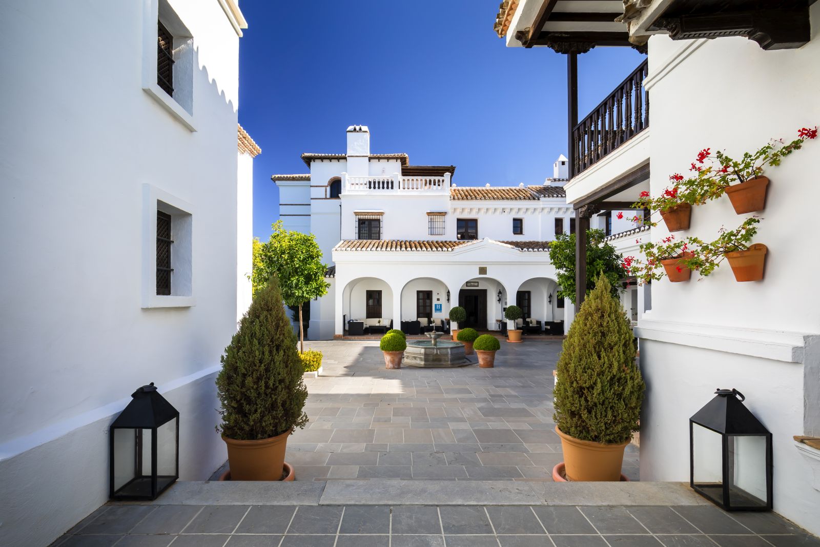 Courtyard lined by the white washed exterior of luxury resort La Bobadilla near Grenada, Spain