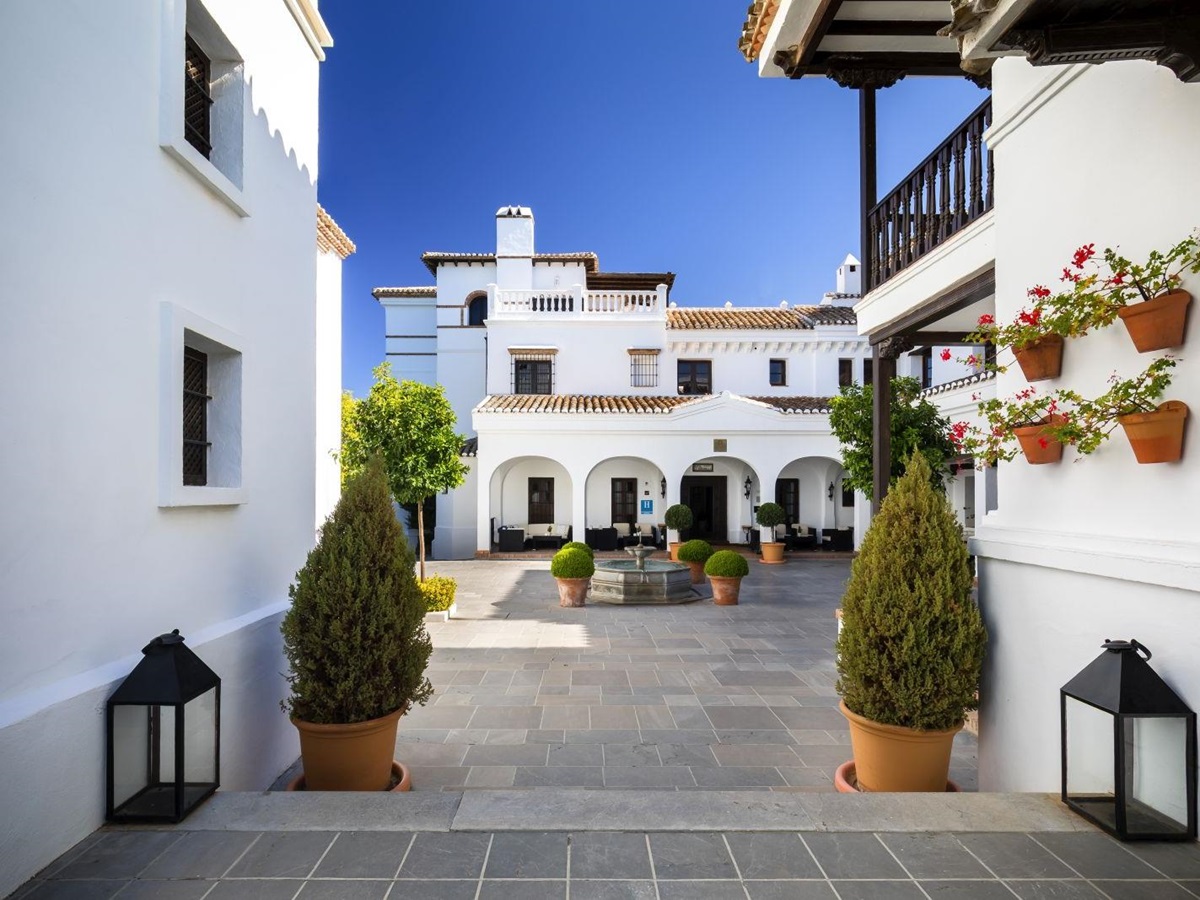 Courtyard lined by the white washed exterior of luxury resort La Bobadilla near Grenada, Spain