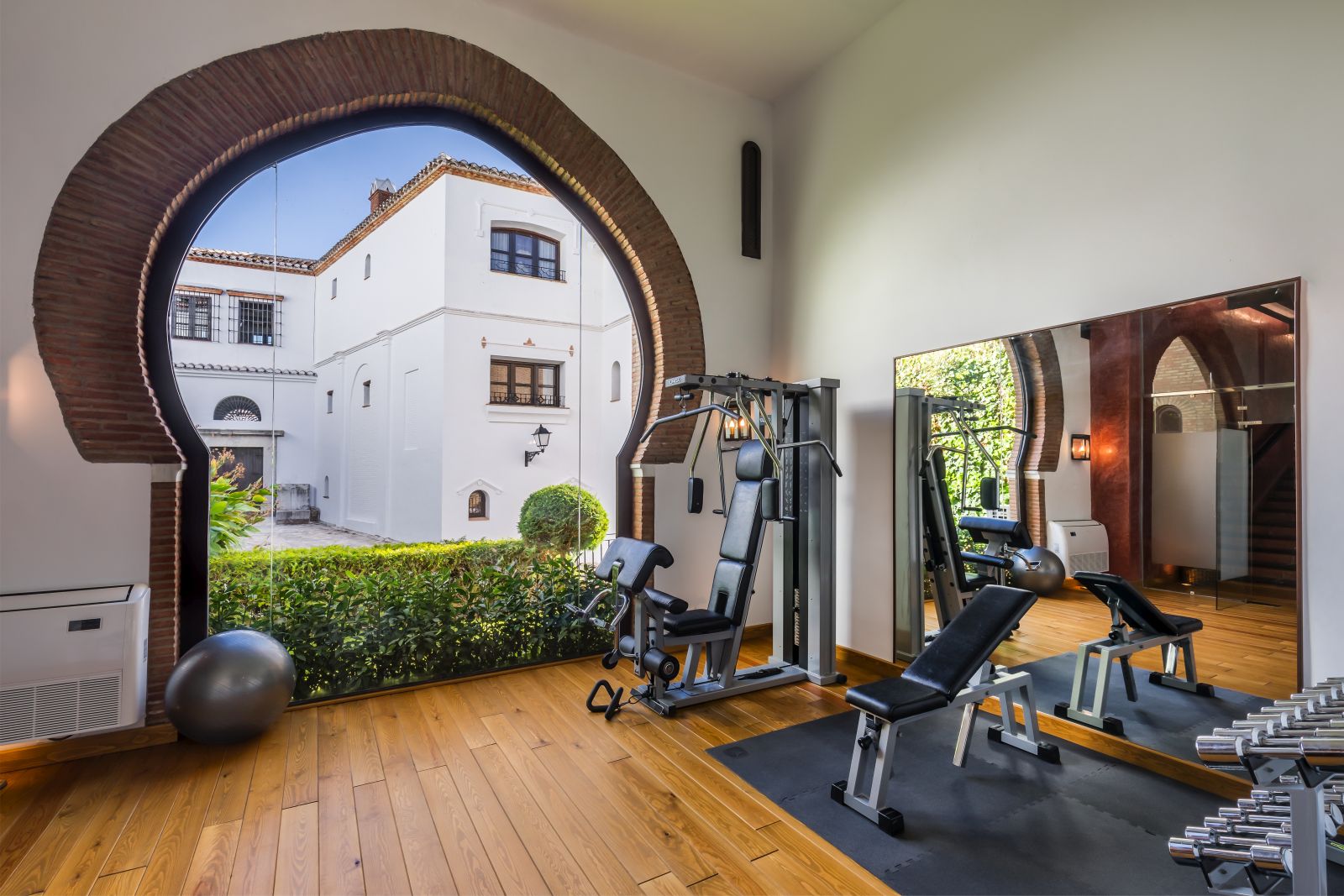 Fully equipped gym with archway into the courtyard at luxury resort La Bobadilla near Grenada, Spain
