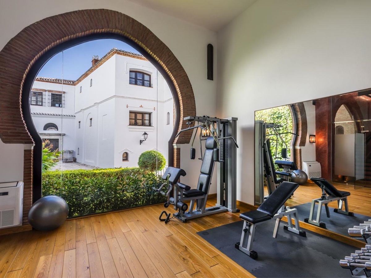 Fully equipped gym with archway into the courtyard at luxury resort La Bobadilla near Grenada, Spain