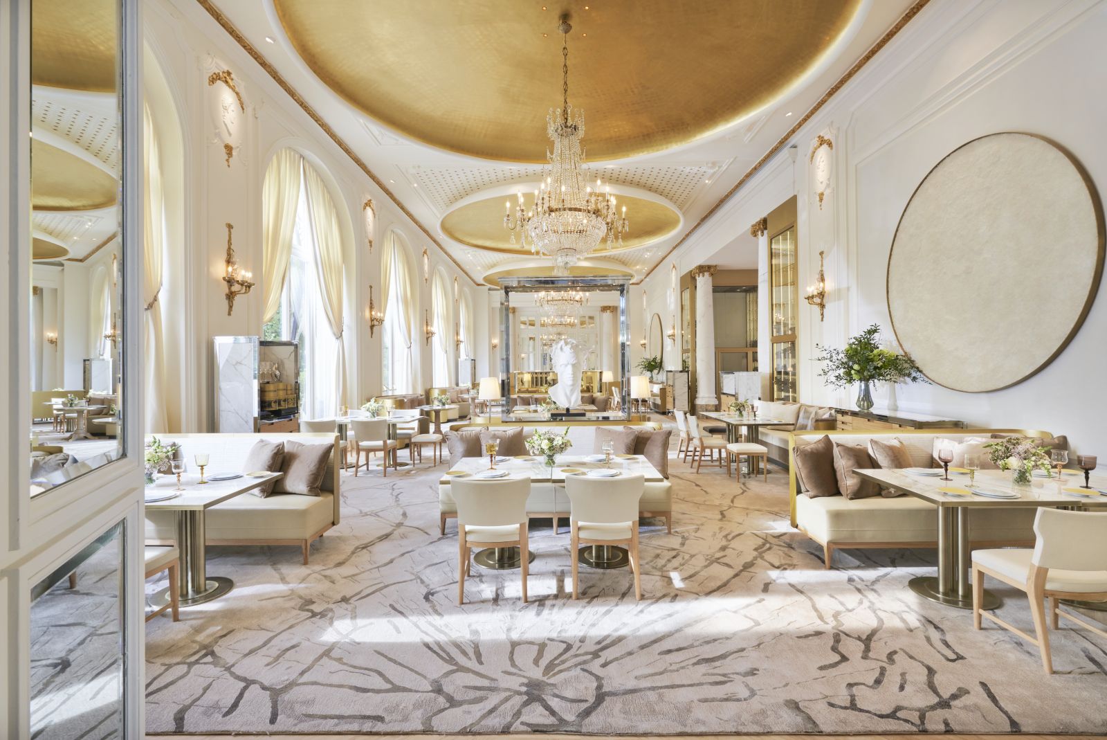 Dining area of Deessa Restaurant at luxury hotel Mandarin Oriental Ritz Madrid with floor to ceiling windows and a grande chandelier