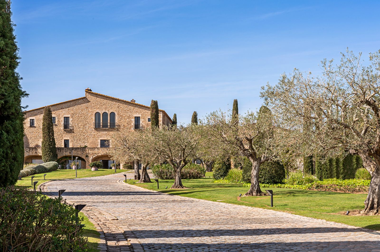 Drive leading up to luxury hotel Mas de Torrent surrounded by lush gardens