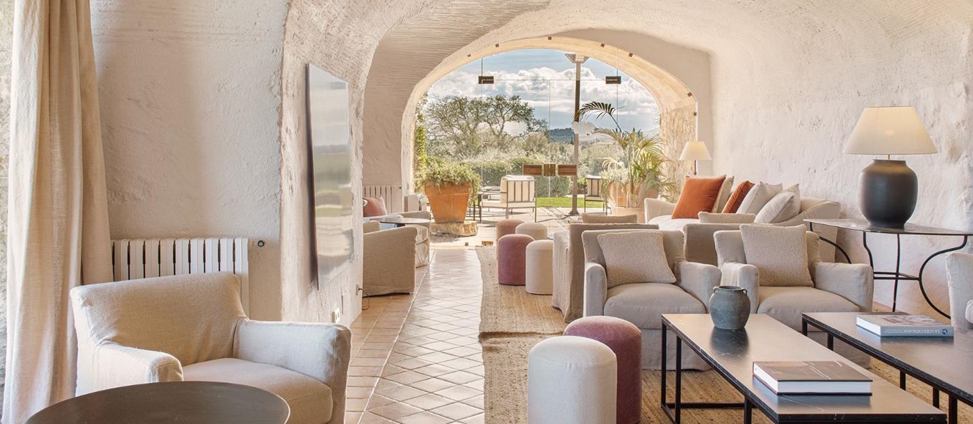 Lounge area at luxury hotel Mas de Torrent in Spain with large window overlooking the lush countryside