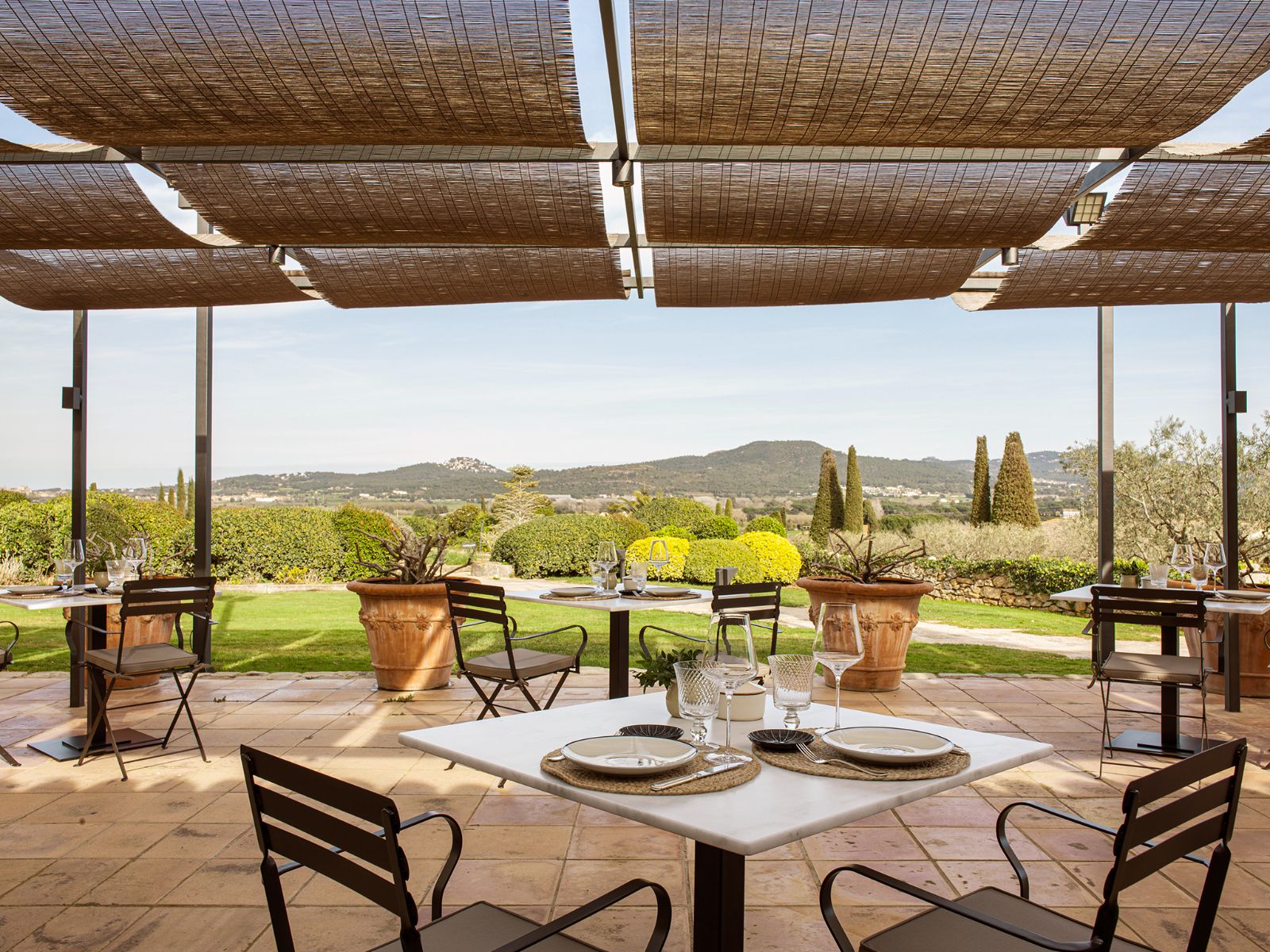 Shaded terrace dining overlooking the lush gardens and countryside at luxury hotel Mas de Torrent in Spain