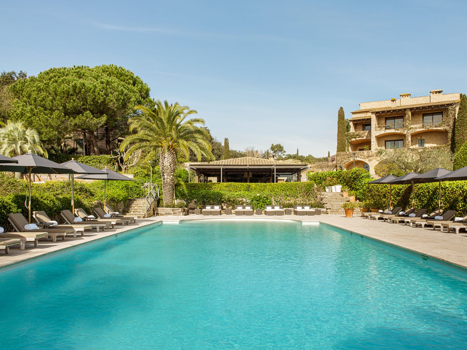 Communal pool with loungers at luxury hotel Mas de Torrent in Spain