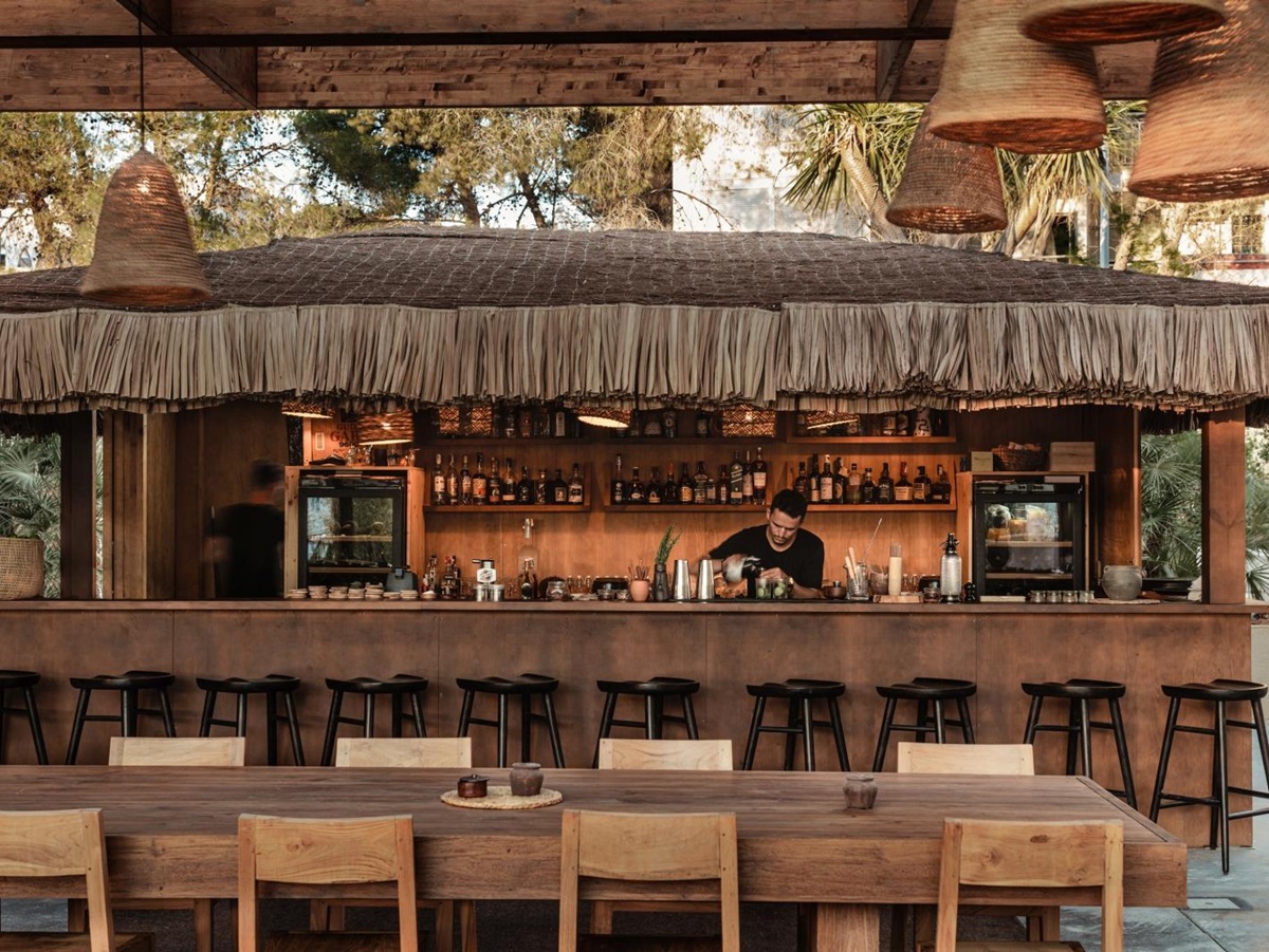 Bartender working at a straw-roofed bar at luxury resort OKU Ibiza