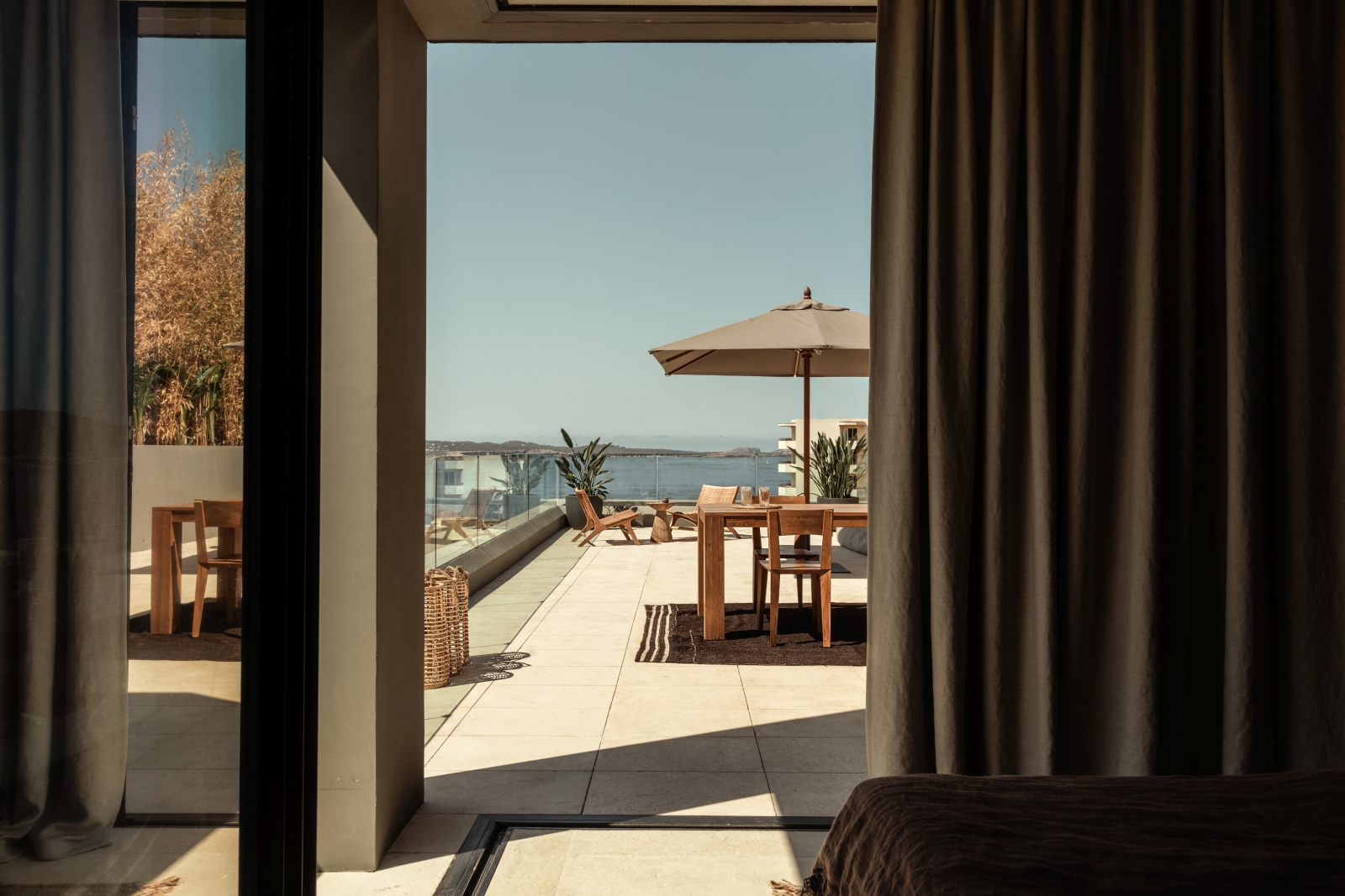 View from a bedroom over a private terrace and the Mediterranean Sea at luxury resort OKU Ibiza