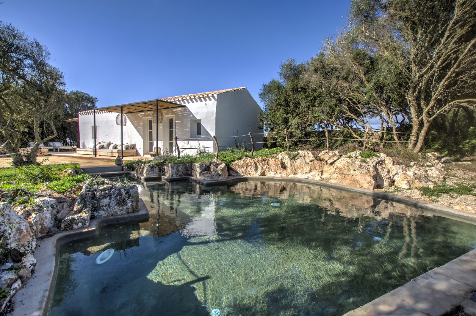 Pool surrounded by rocks at luxury hotel Torre Vella Fontenille in Menorca, Spain
