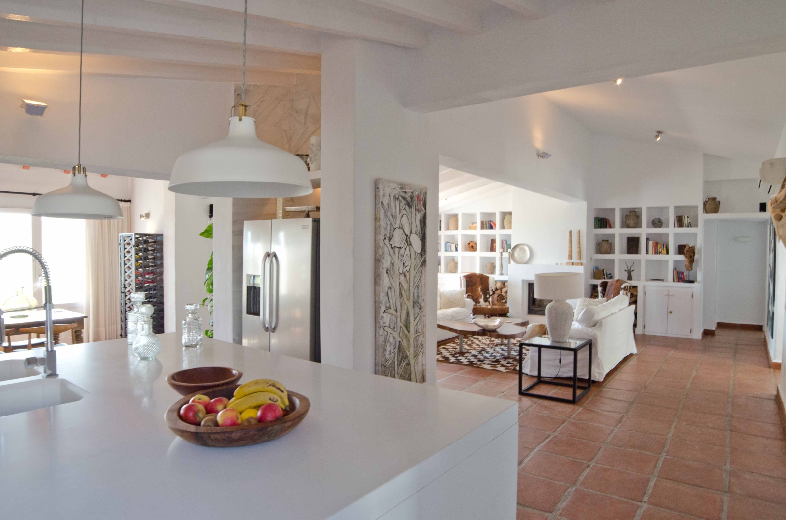 Kitchen island and lounge with decorative shelving at Spanish luxury villa El Refugio
