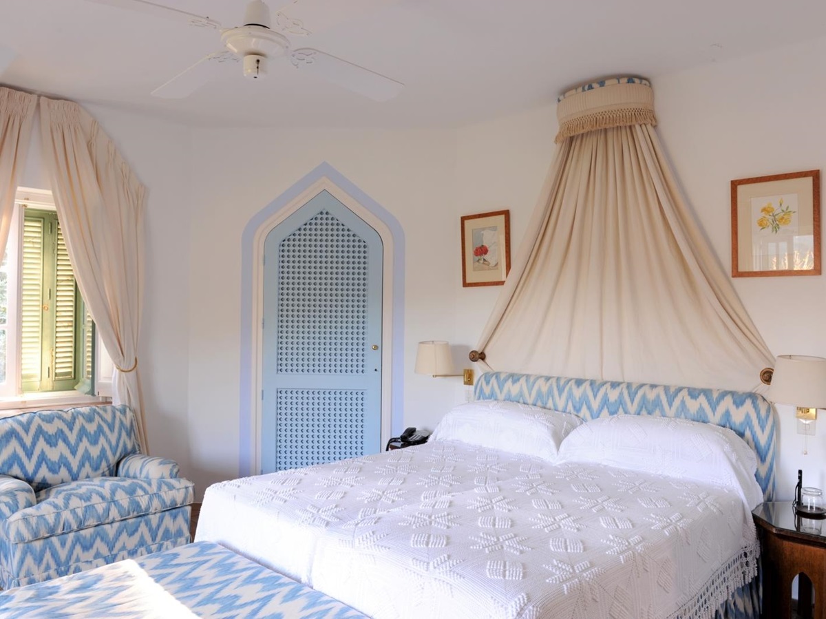 Bedroom with double bed, bedside tables, lamps, picture frames and armchair at Torre de Tramores in Andalucía, Spain