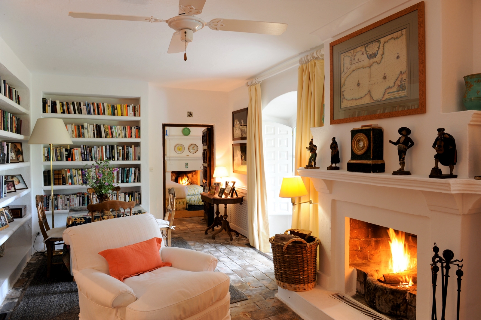 Study with fireplace, armchair, table chairs and bookcases at Torre de Tramores in Andalucía, Spain