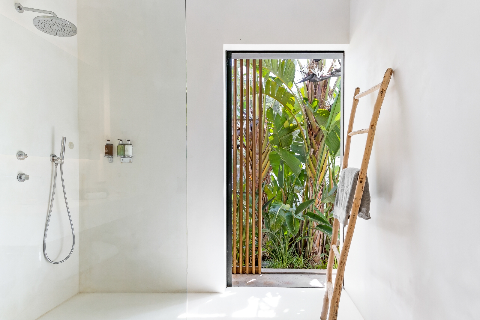 White, light-flooded bathroom with wooden feature