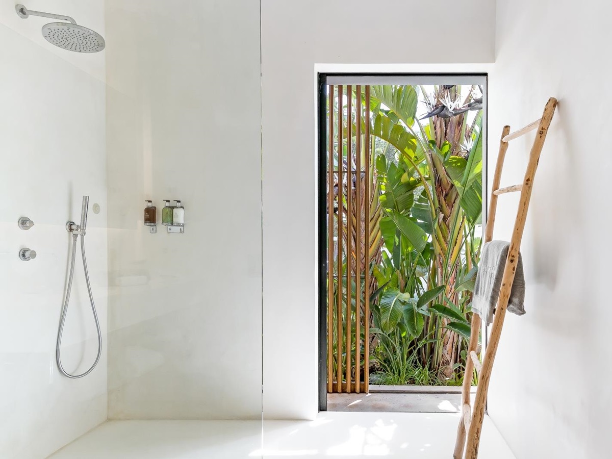White, light-flooded bathroom with wooden feature