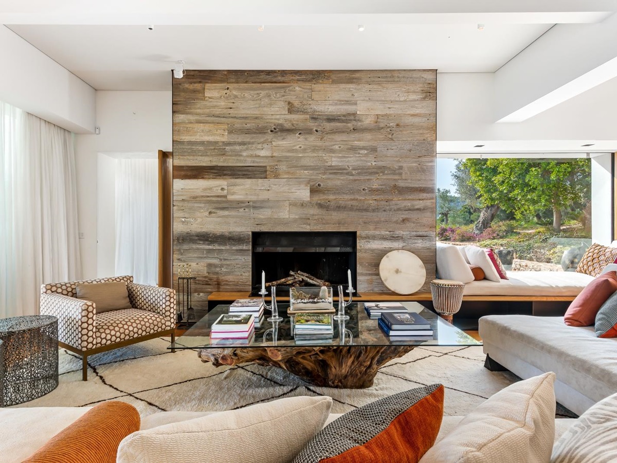 Indoor lounge of Villa Xi, equipped with fire place and feature wooden coffee table