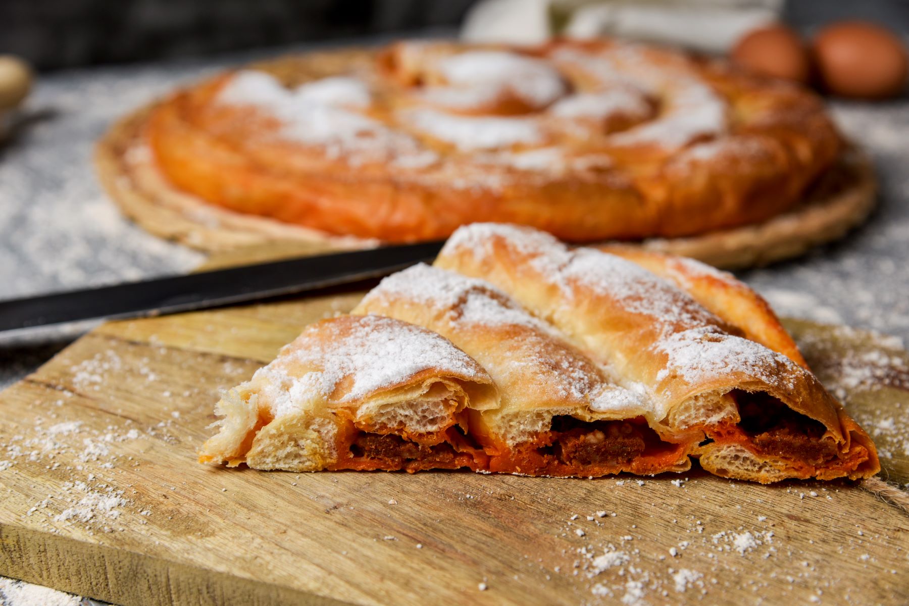 Close up of a Mallorcan ensaimada pastry dusted with icing sugar
