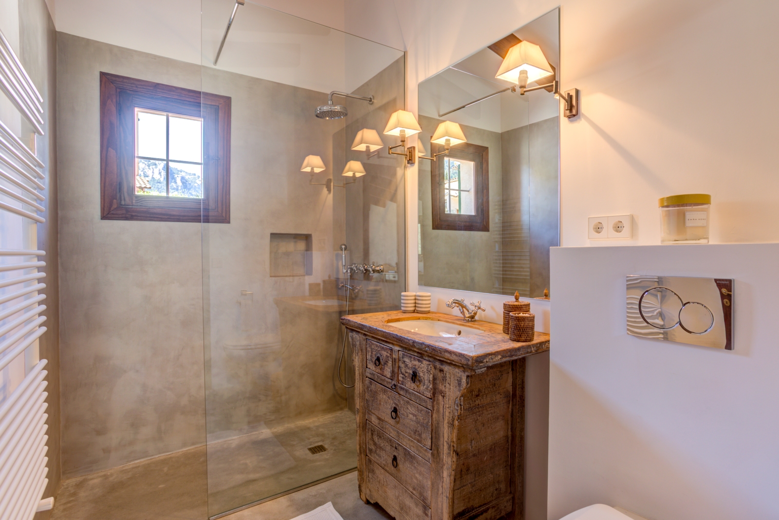 Bathroom with a shower, wooden sink unit, large mirror, towel rail, toilet and small window at Can Canals in Mallorca, Spain