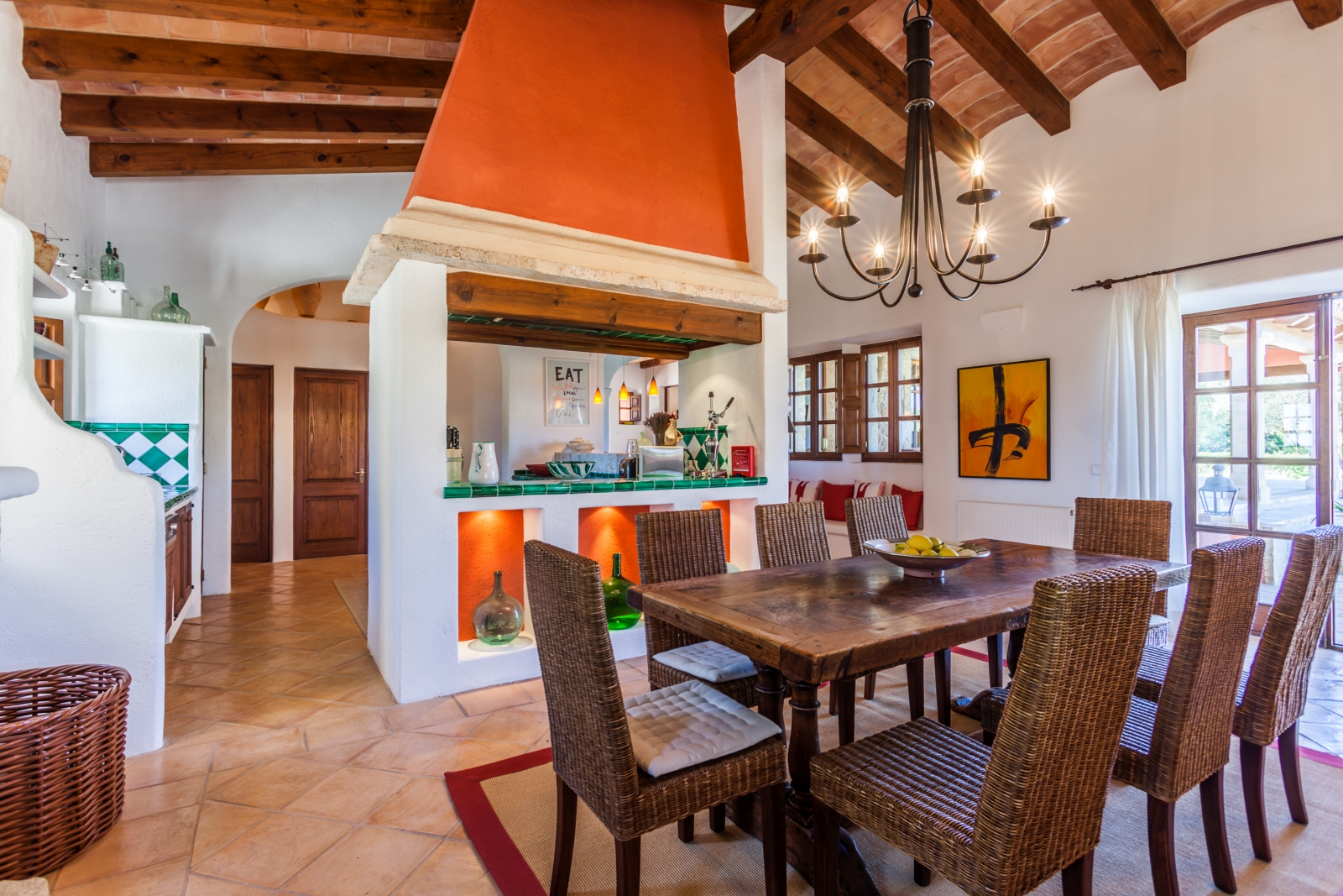 Dining area in kitchen with wooden table, 8 chairs, overhanging light & French doors to patio at Can Suelo in Mallorca, Spain