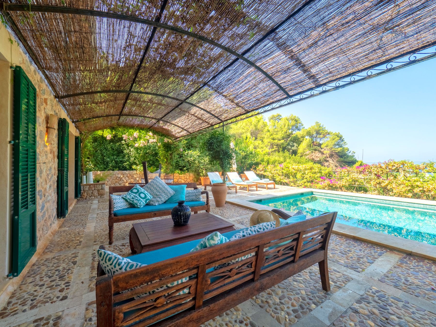Terrace with seating and views of pool at Villa Caleta, Mallorca
