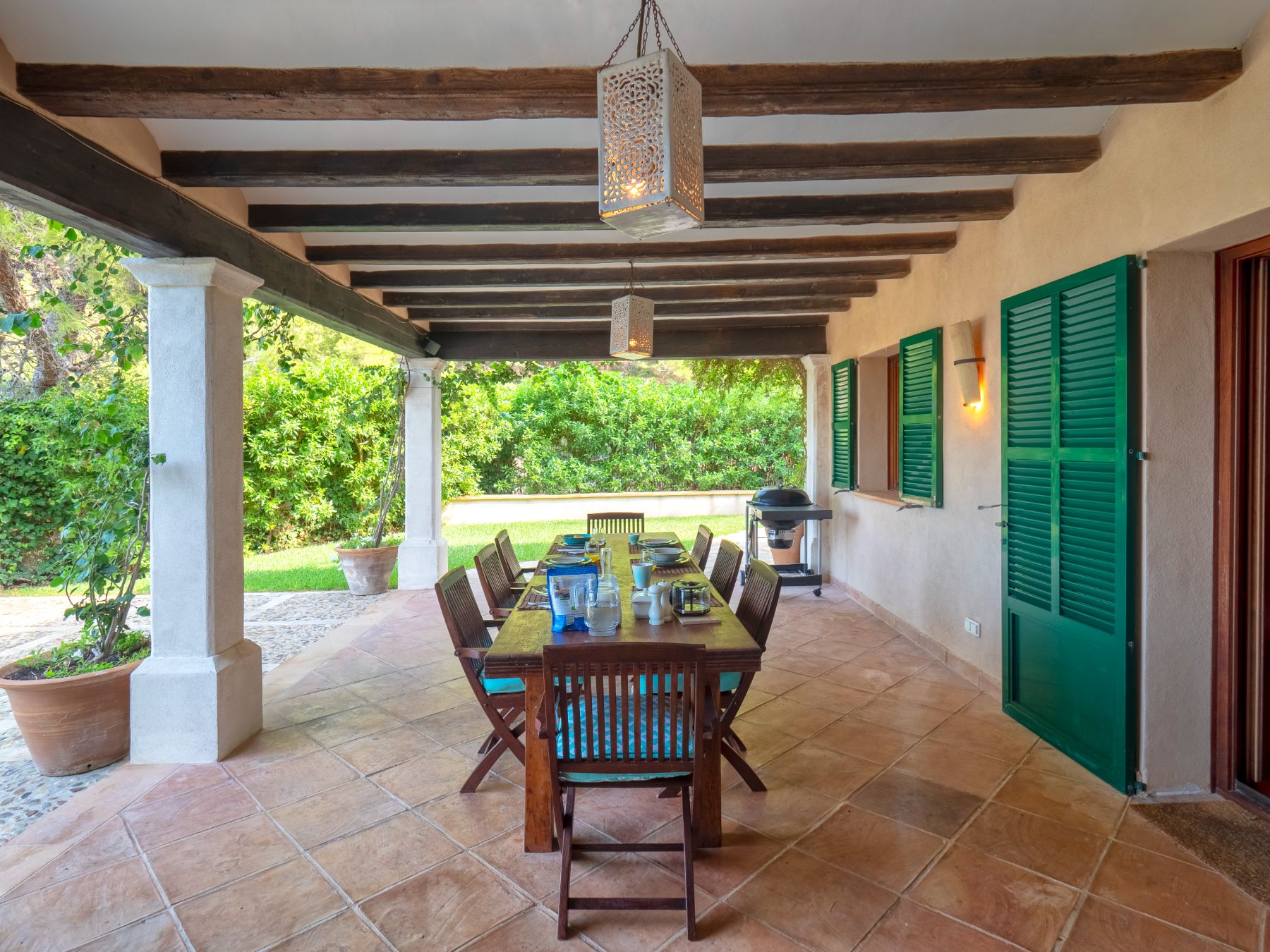 Covered terrace with dining table at Villa Caleta, Mallorca